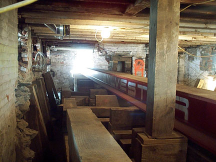 A move of historic proportions: Massive steel I-beams positioned in the basement will allow workers to lift the 300-ton house from its old foundation and carefully settle it onto the new.