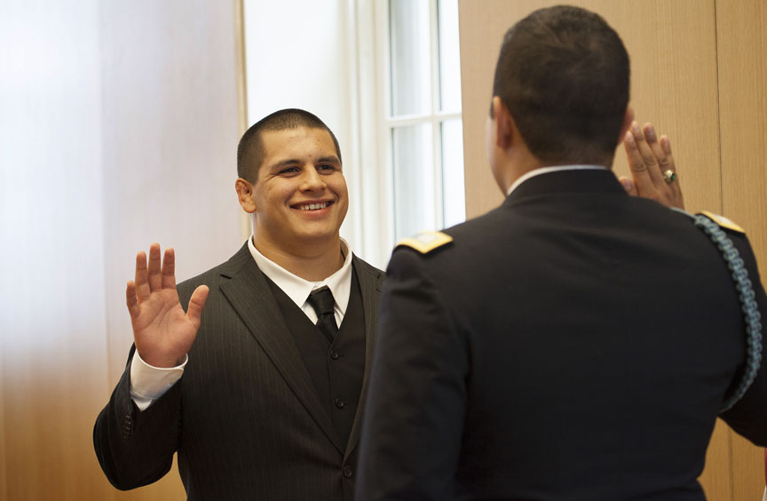 Practicing military medicine: Marcos Aranda receives his commission into the U.S., Army from Capt. David Flores. He will continue his education at Alpert Medical School in the fall.