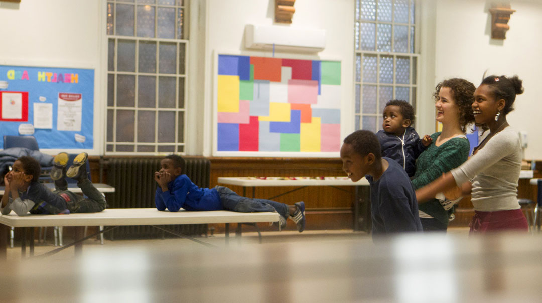 Refugee youth tutoring: Senior Sabine Adrian, a student project leader in the Refugee Communities group, watches a slideshow with children she tutors through the Brown Refugee Youth Tutoring and Enrichment Program. Credit: Mike Cohea/Brown University Refugee youth tutoring: Senior Sabine Adrian, a student project leader in the Refugee Communities group, watches a slideshow with children she tutors through the Brown Refugee Youth Tutoring and Enrichment Program. Credit: Mike Cohea/Brown University